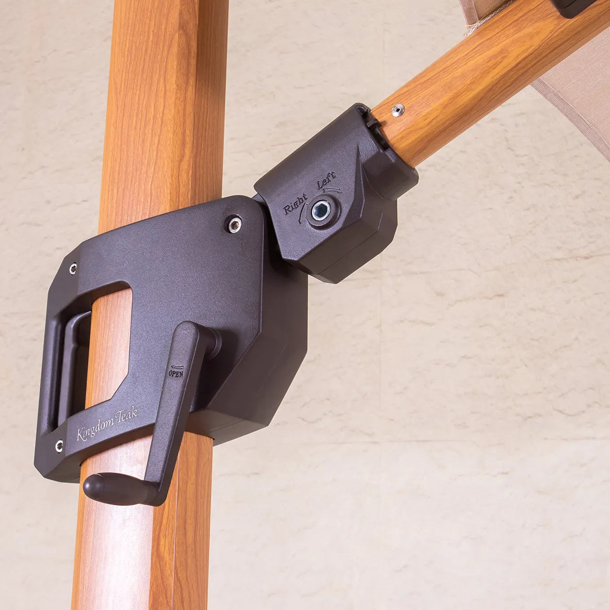 Black mechanism attached to a wooden parasol pole with beige canopy in background