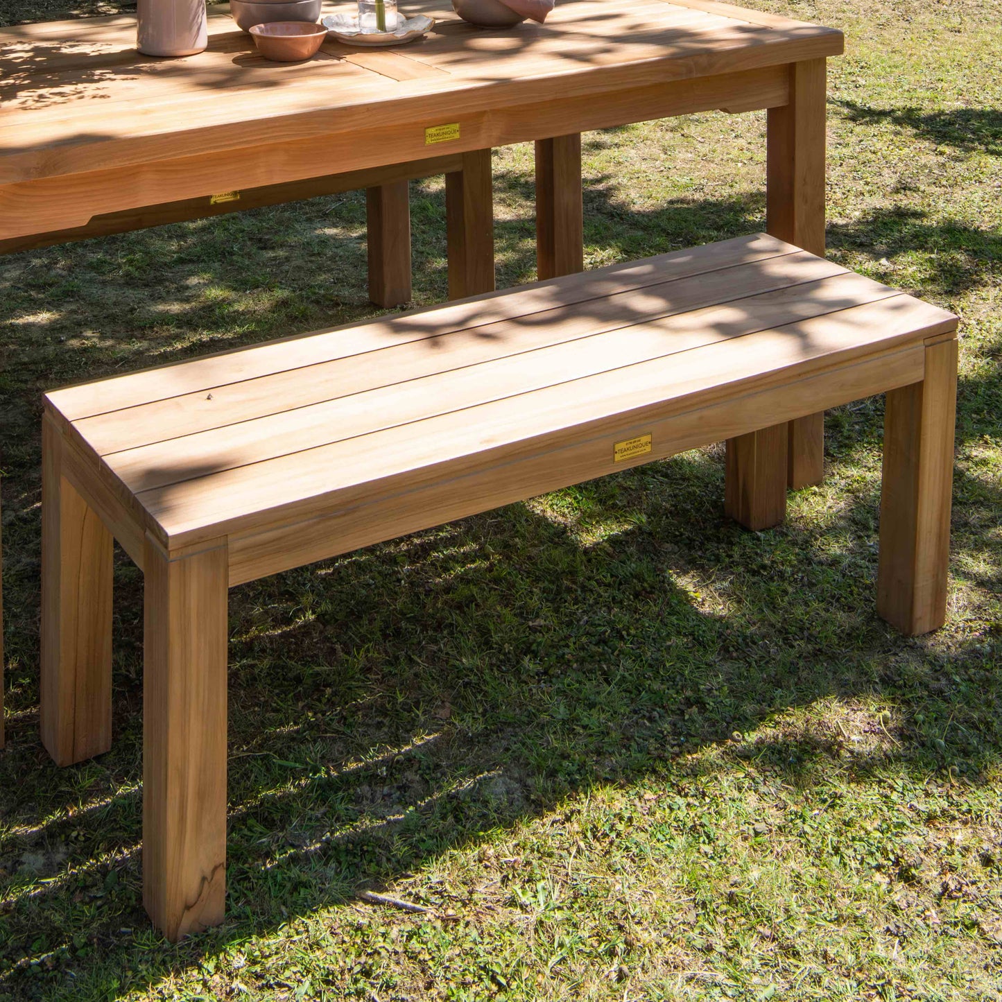 Teak wooden bench and table set on grass