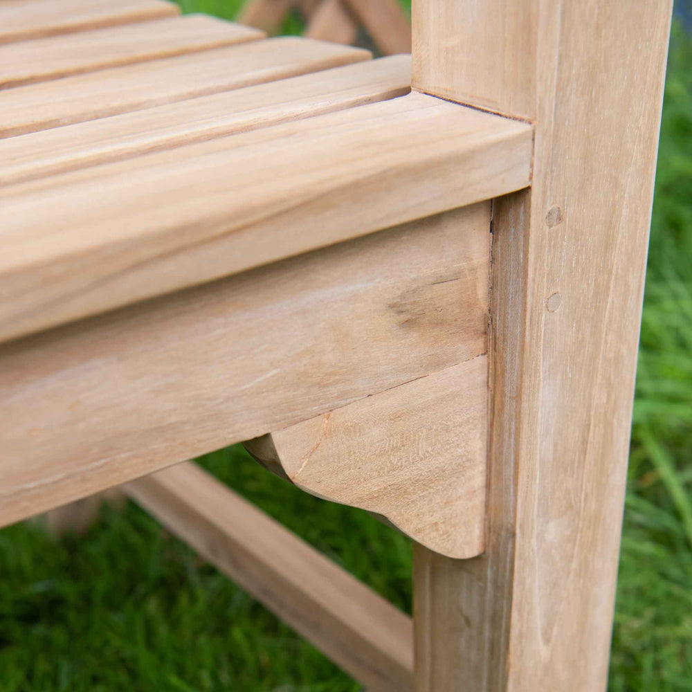 
                  
                    Close up shot of teak bench where seat meets the armrests
                  
                