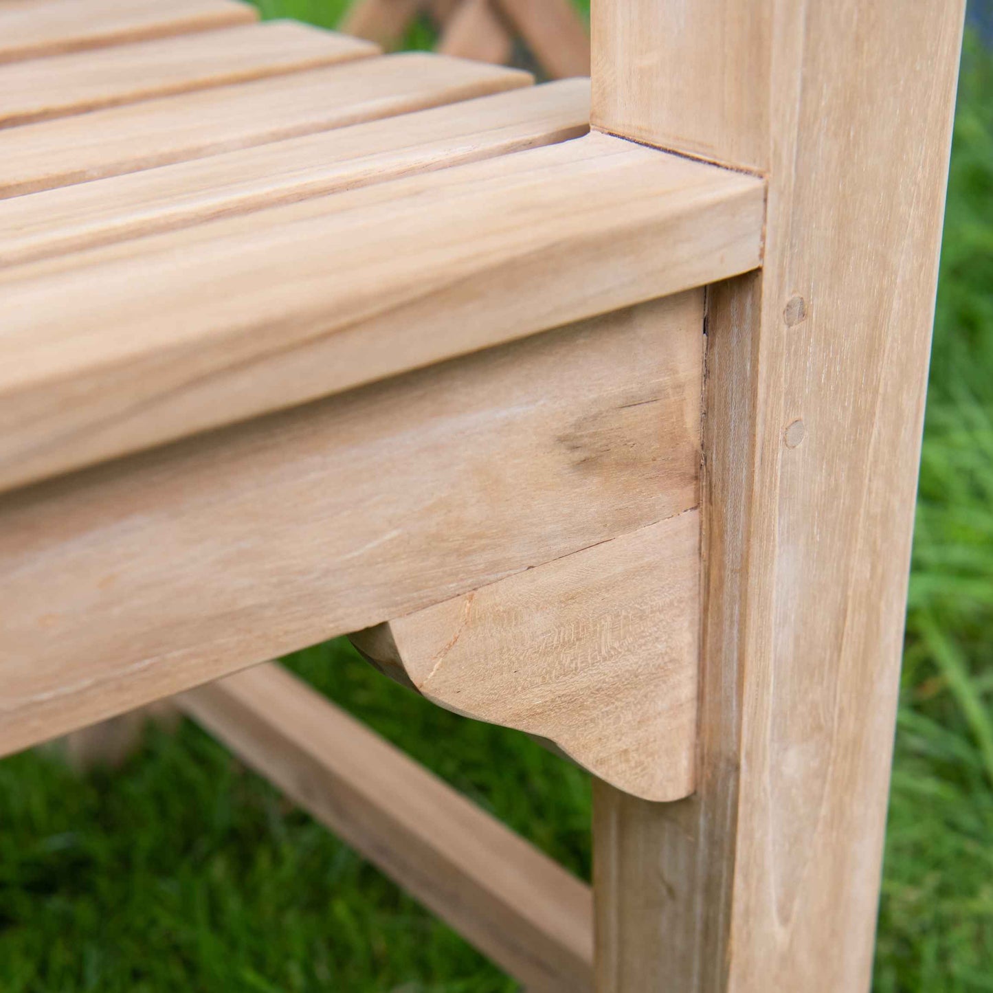 Close up shot of teak bench where seat meets the armrests